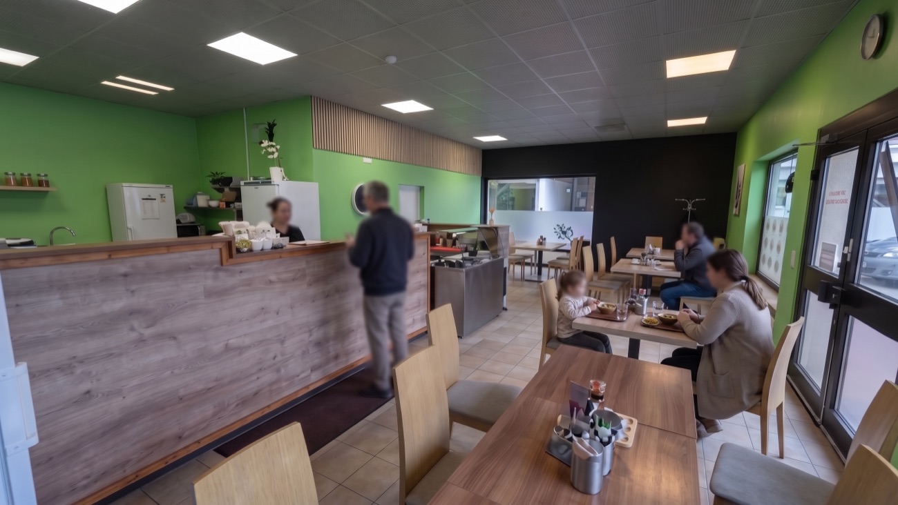 Heller Gastraum von Lili&rsquo;s Asia Imbiss mit grünen Wänden, Holztresen und Tischen, an denen Gäste essen